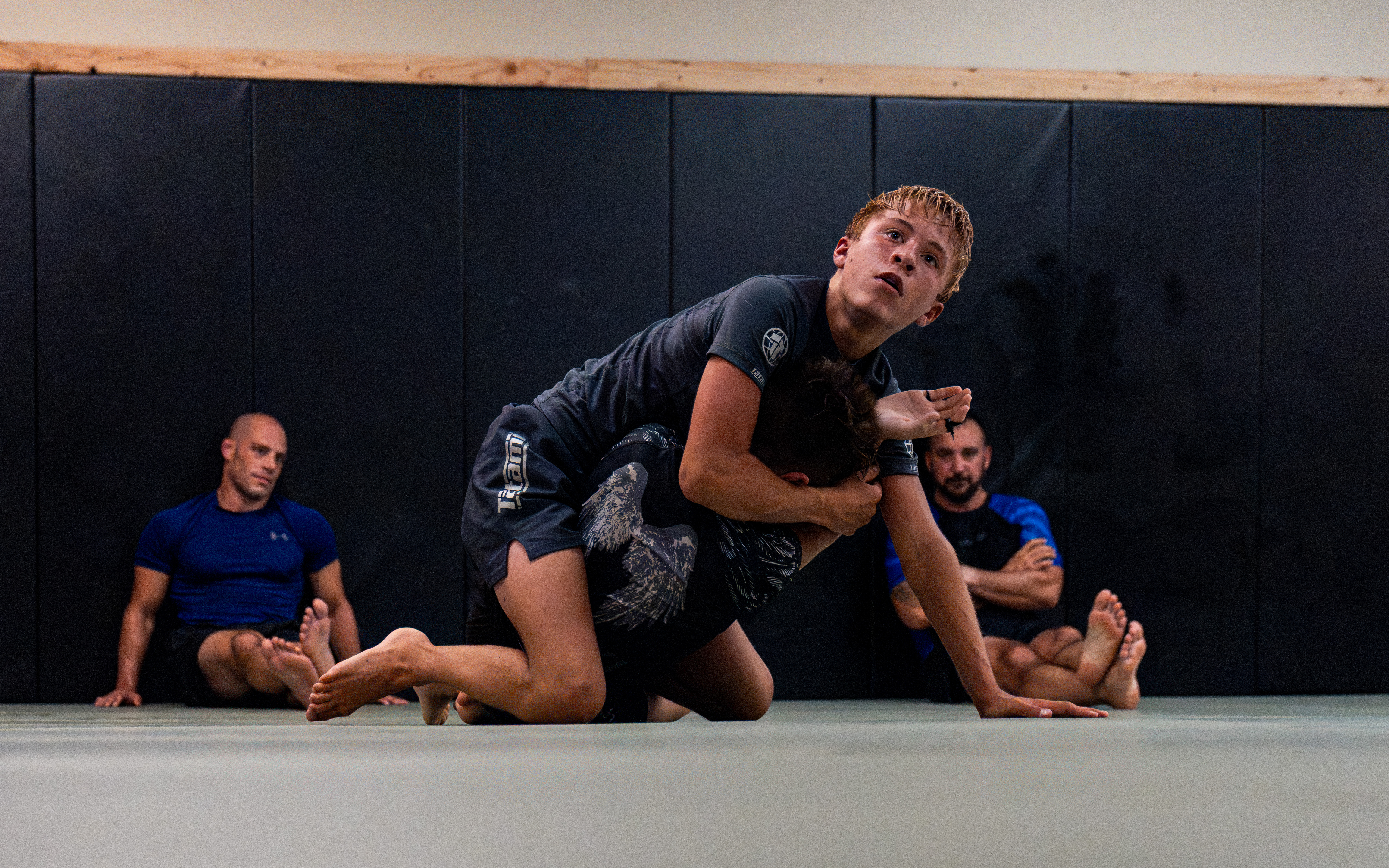 Two students sparring while teammates observe