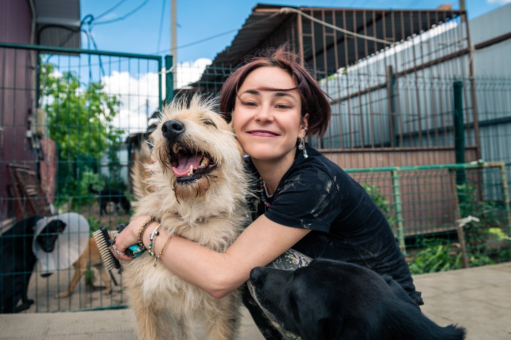 An FTLOP staff member hugging a happy rescue dog