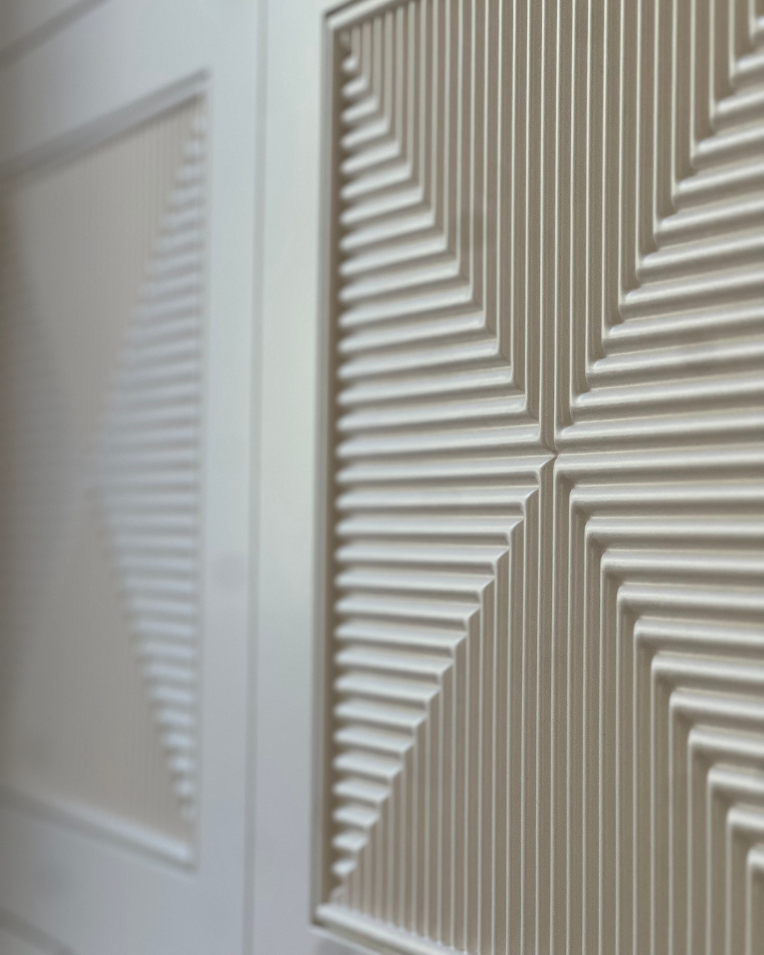 Close up of custom cabinet doors featuring intricate CNC-milled geometric linear relief patterns.