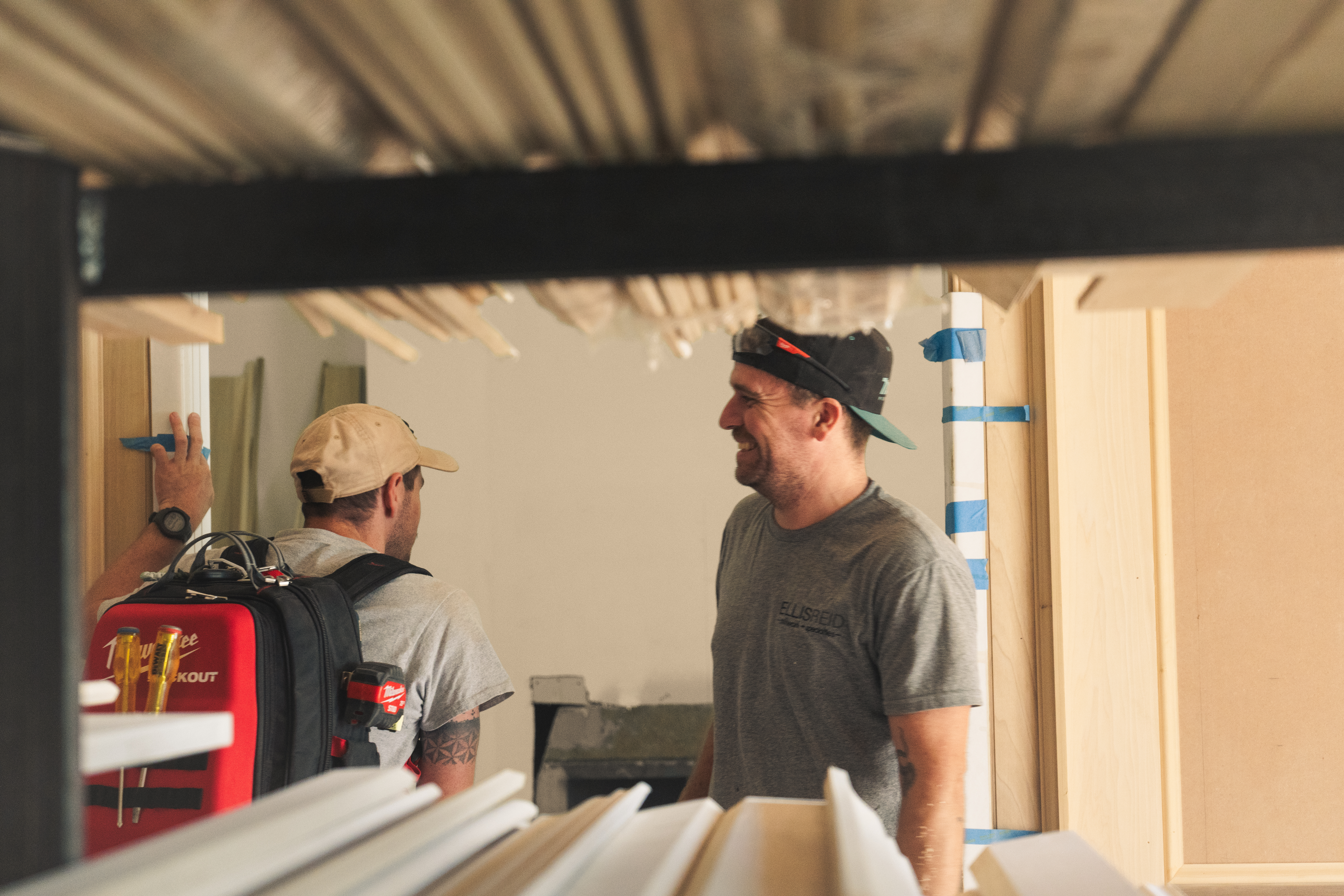 Two Ellis-Reid crew members laughing while marking a wall