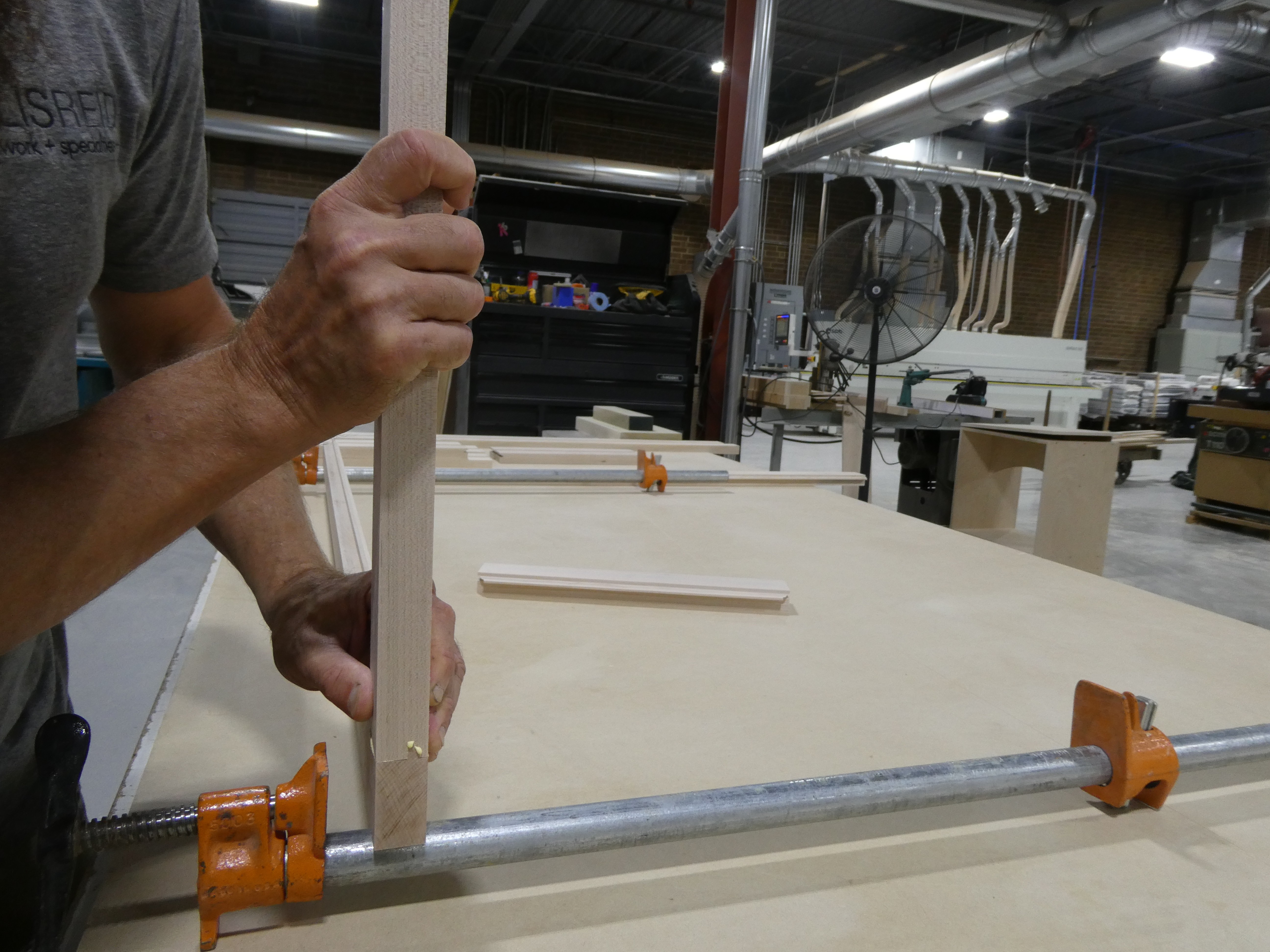 A frame member clamped up and being fit on the assembly bench.