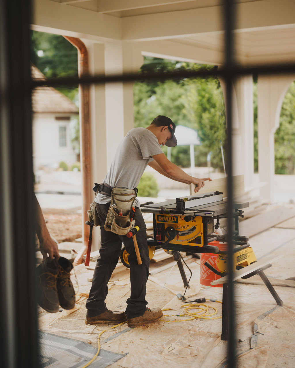 Carpenter ripping stock on a jobsite table saw