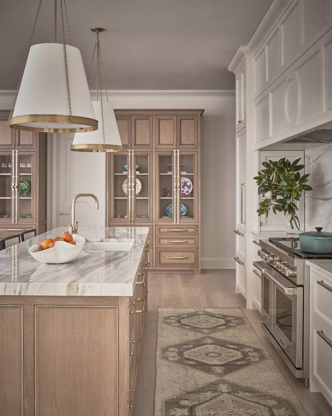 A transitional kitchen featuring stained white oak glass-front cabinets and a matching wood kitchen island.