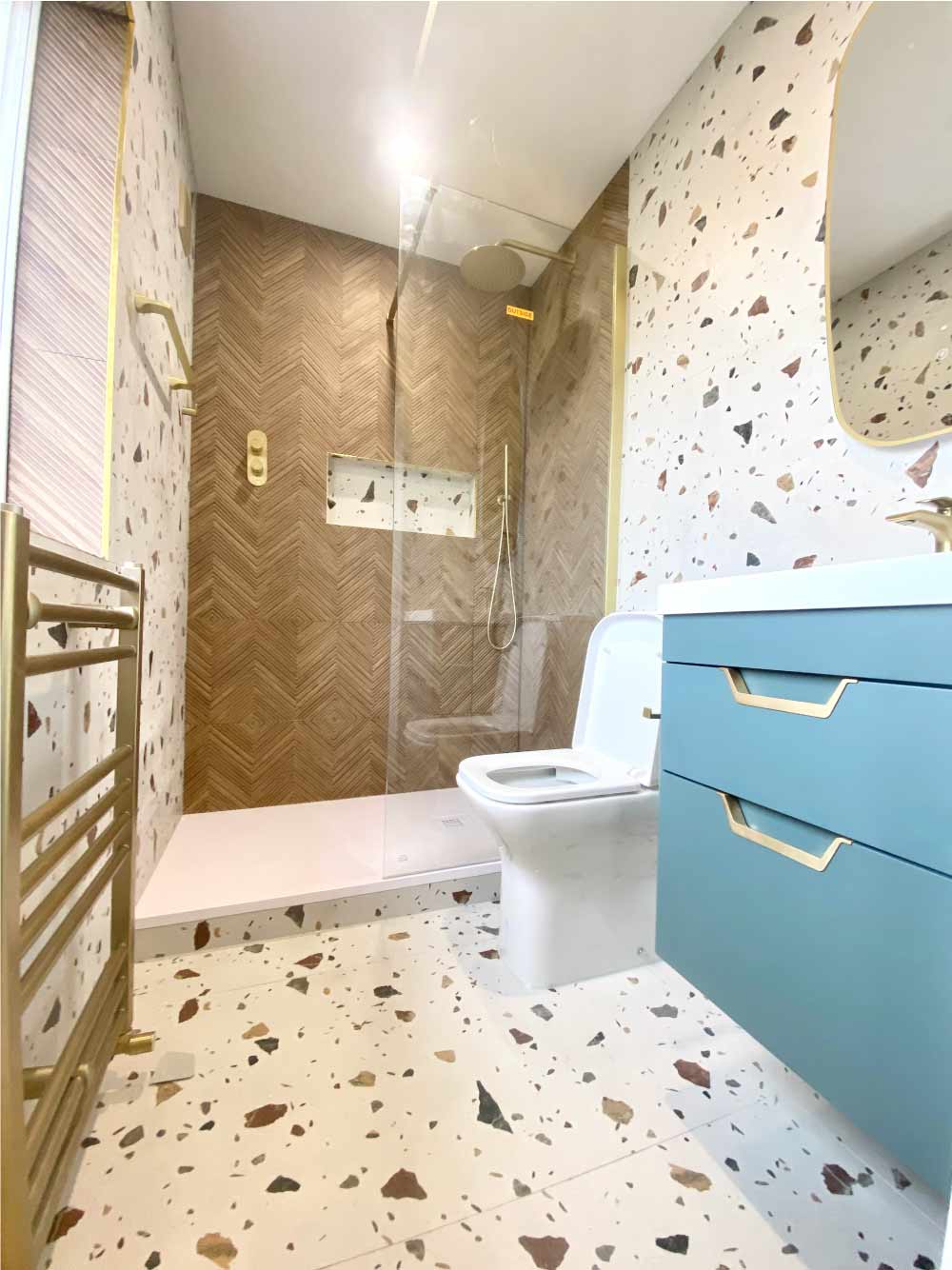Finished bathroom with walk-in shower and gold fittings completed by Calico Joinery in Edinburgh