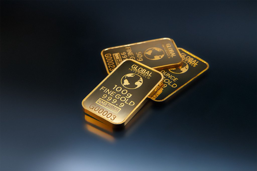 Three stacked Global Intergold gold bars on dark background