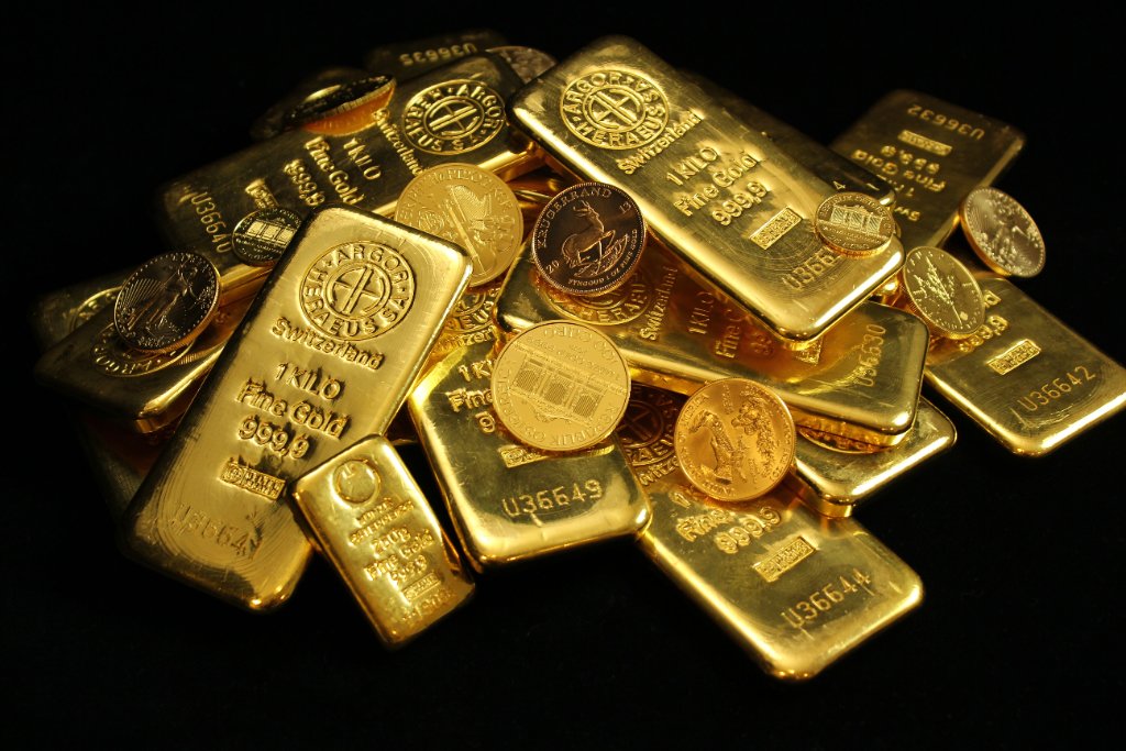 Gold coins spread across dark reflective surface