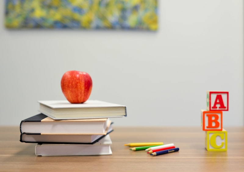 School desk with books, an apple and alphabet blocks