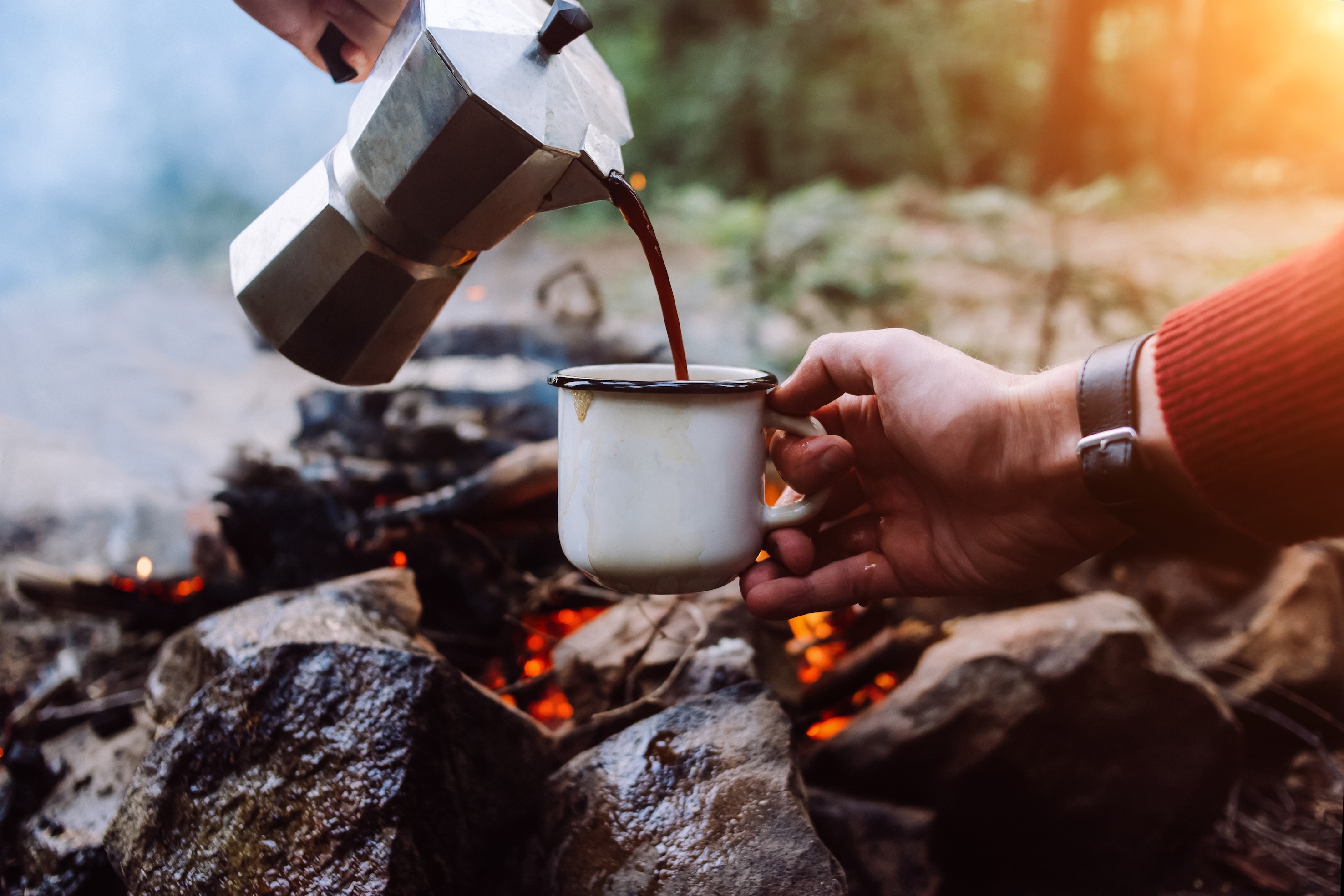 Kaffee wird am See in eine Tasse gegossen