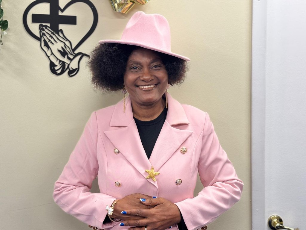 Portrait of Beltha Onjeme Mbile, Co-Founder of Stream Garden TV, wearing a light pink blazer and fedora hat