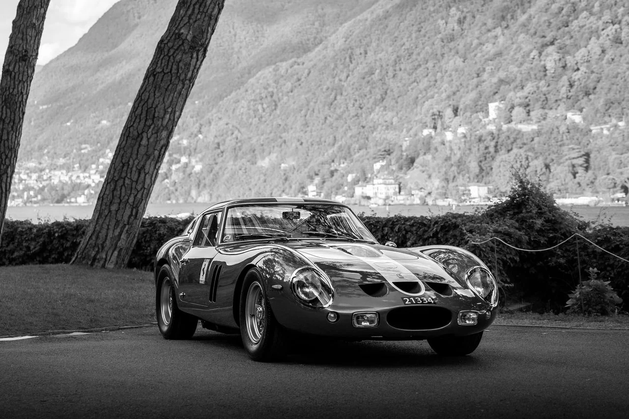 A vintage Ferrari 250 GTO photographed in three-quarter view by a lake