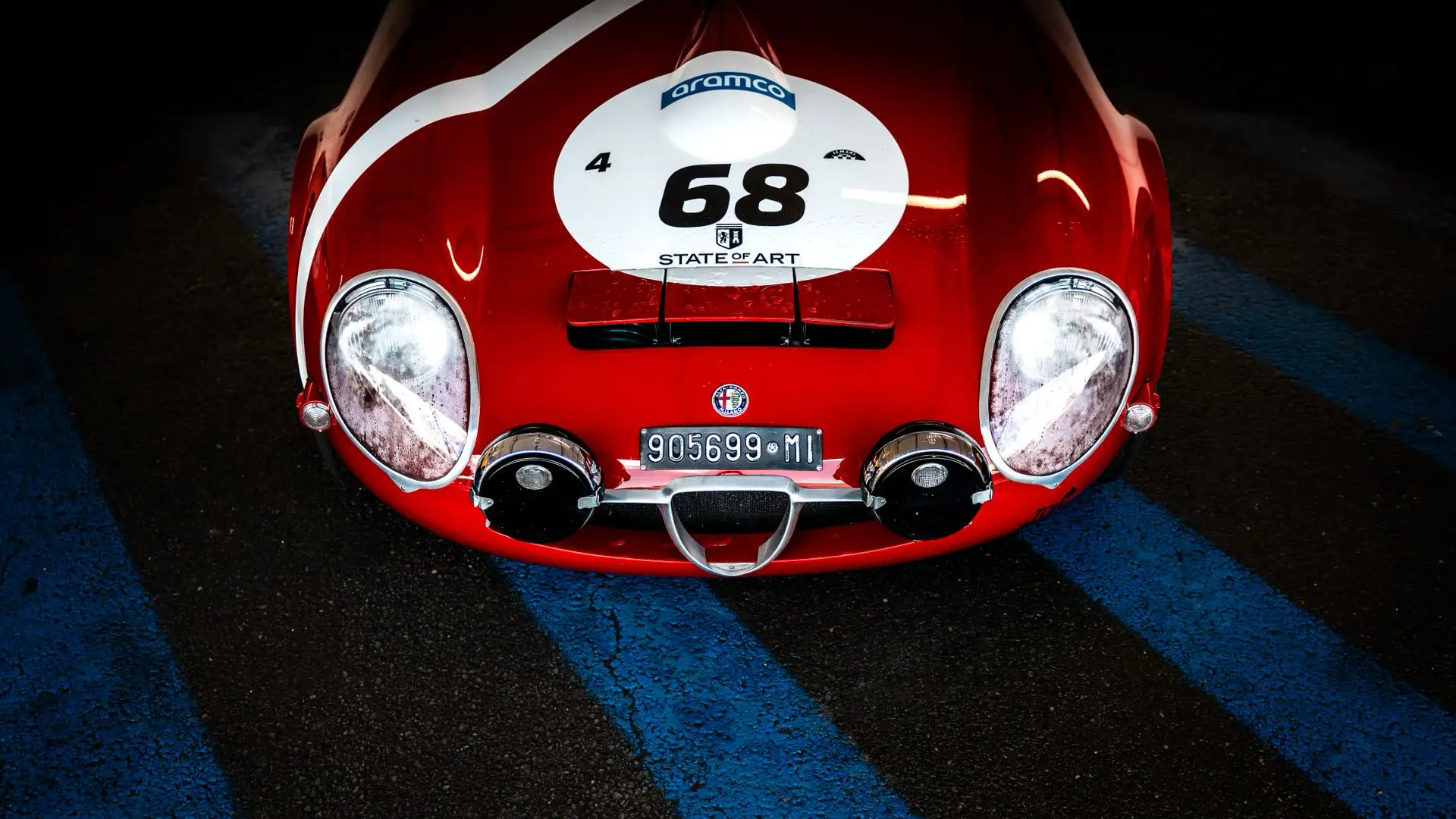 Detail of a red vintage racing car with number 68 livery