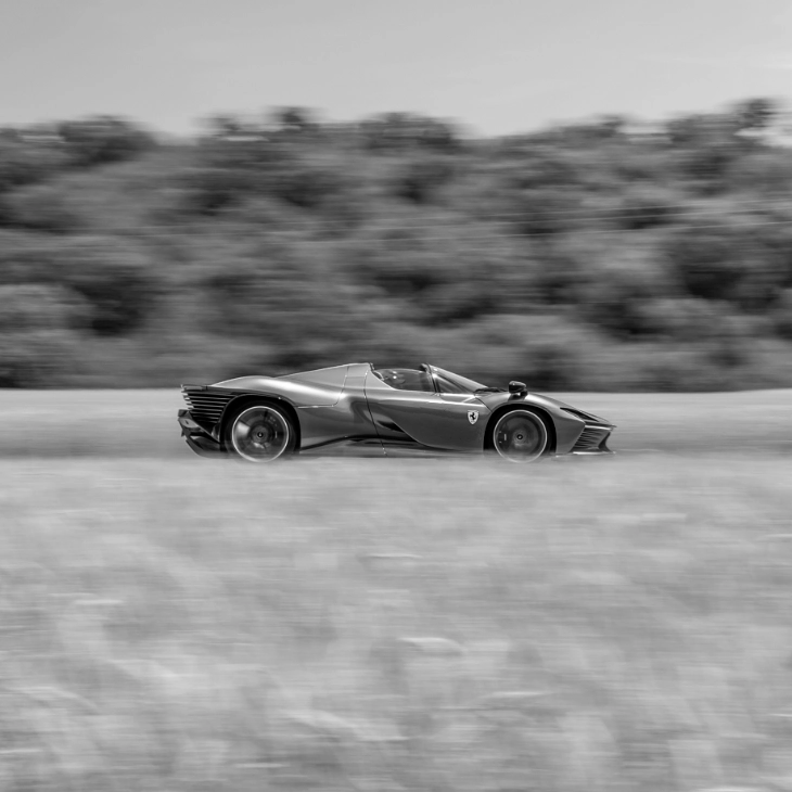 Ferrari Daytona SP3 at speed, panned in black and white