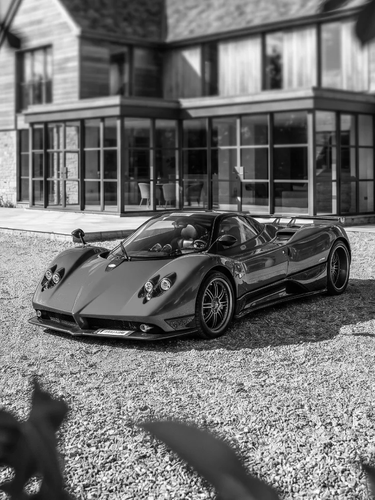 Pagani Zonda on a gravel driveway before a modern house