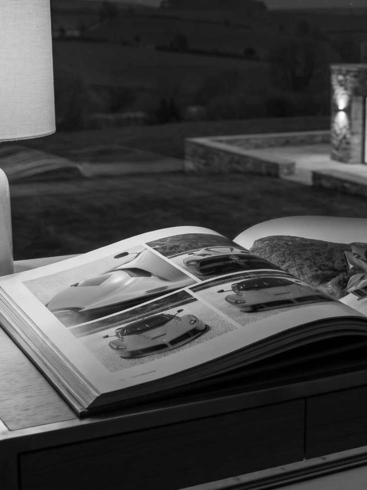 Open book of LaFerrari photography on a wooden desk