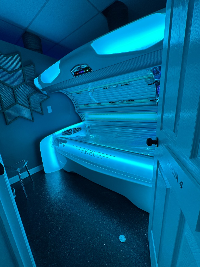 KBL tanning bed glowing blue in private room