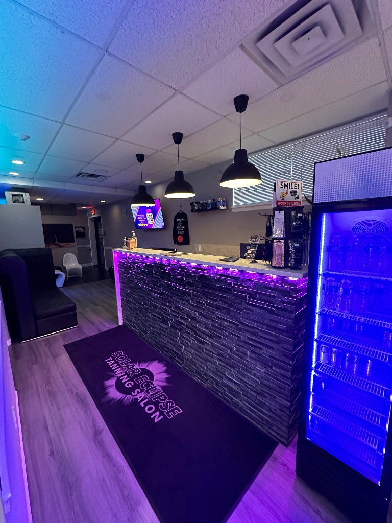 Solar Eclipse Tanning Salon front desk with neon lighting