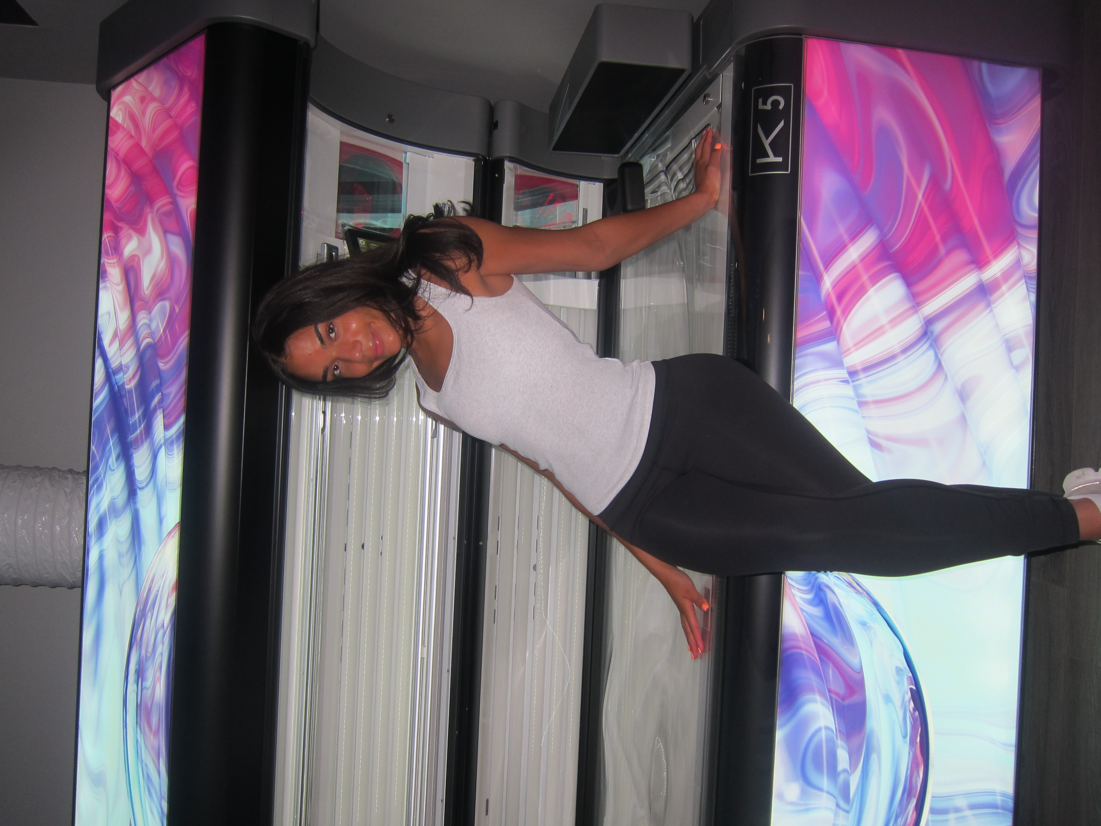 Laura in the K5 stand-up tanning booth at Solar Eclipse Tanning