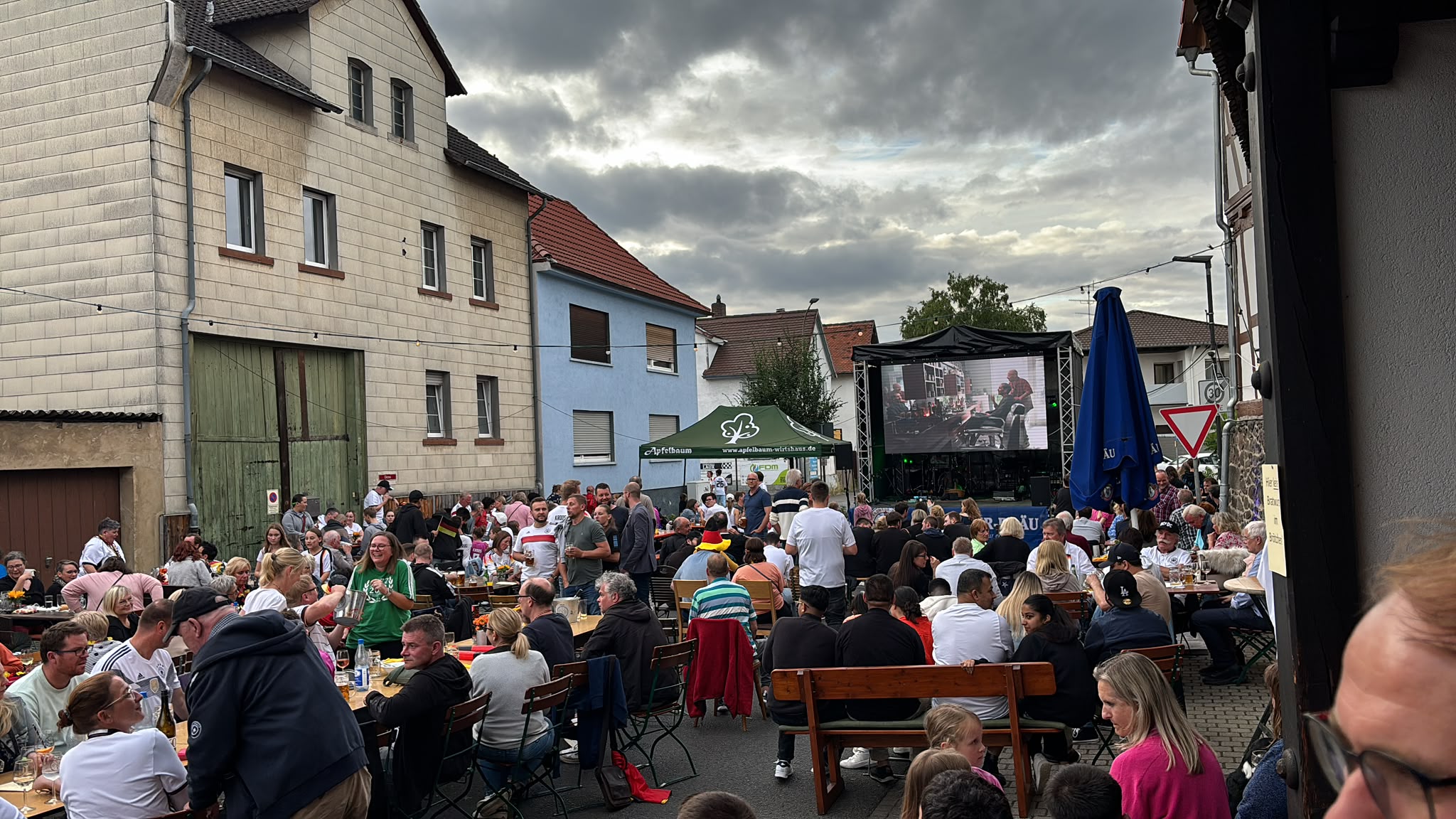 Gefüllte Biertischgarnituren vor dem Festzelt bei einer Veranstaltung beim Philipp