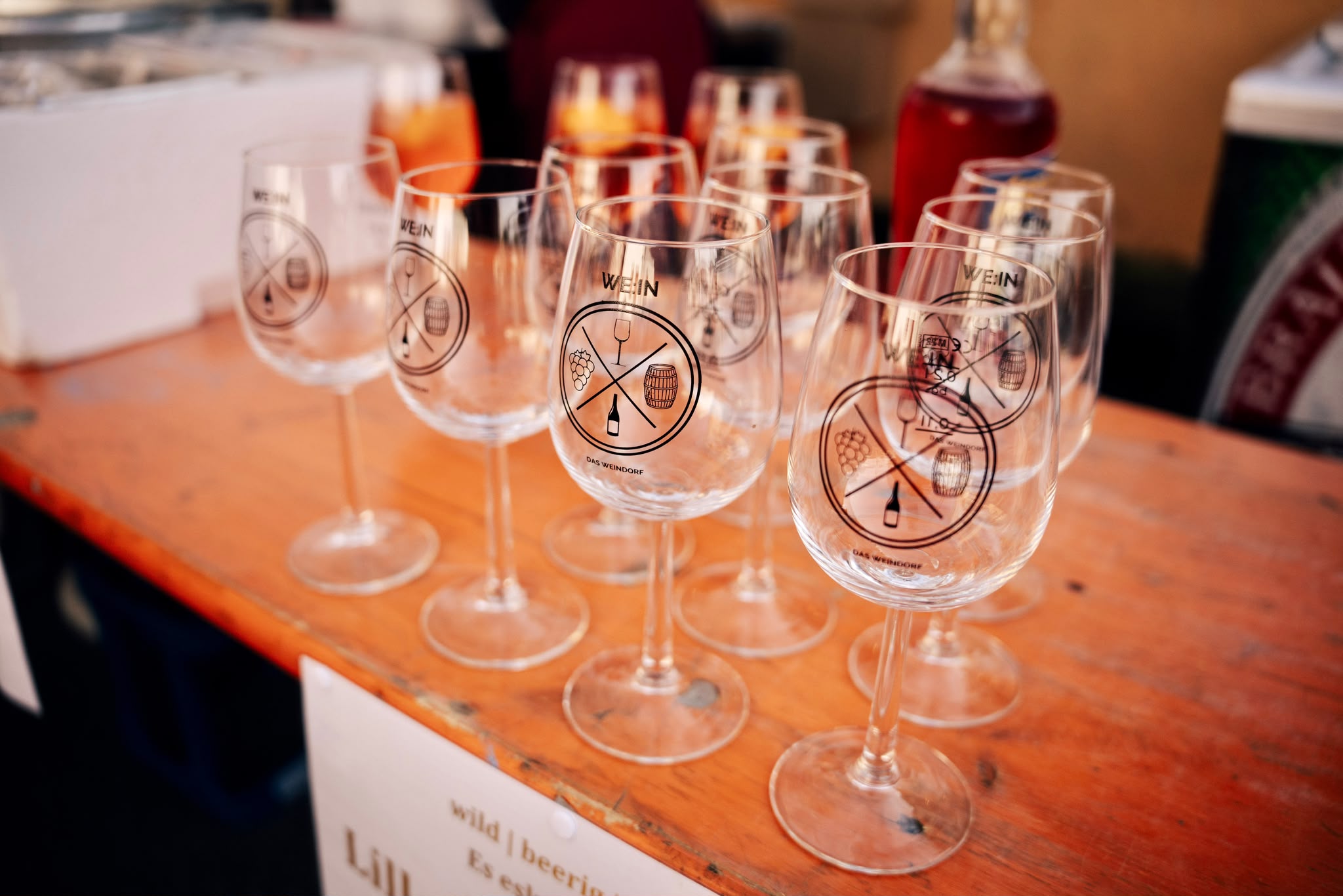 Weingläser mit Weindorf-Logo auf einer Bierzeltgarnitur