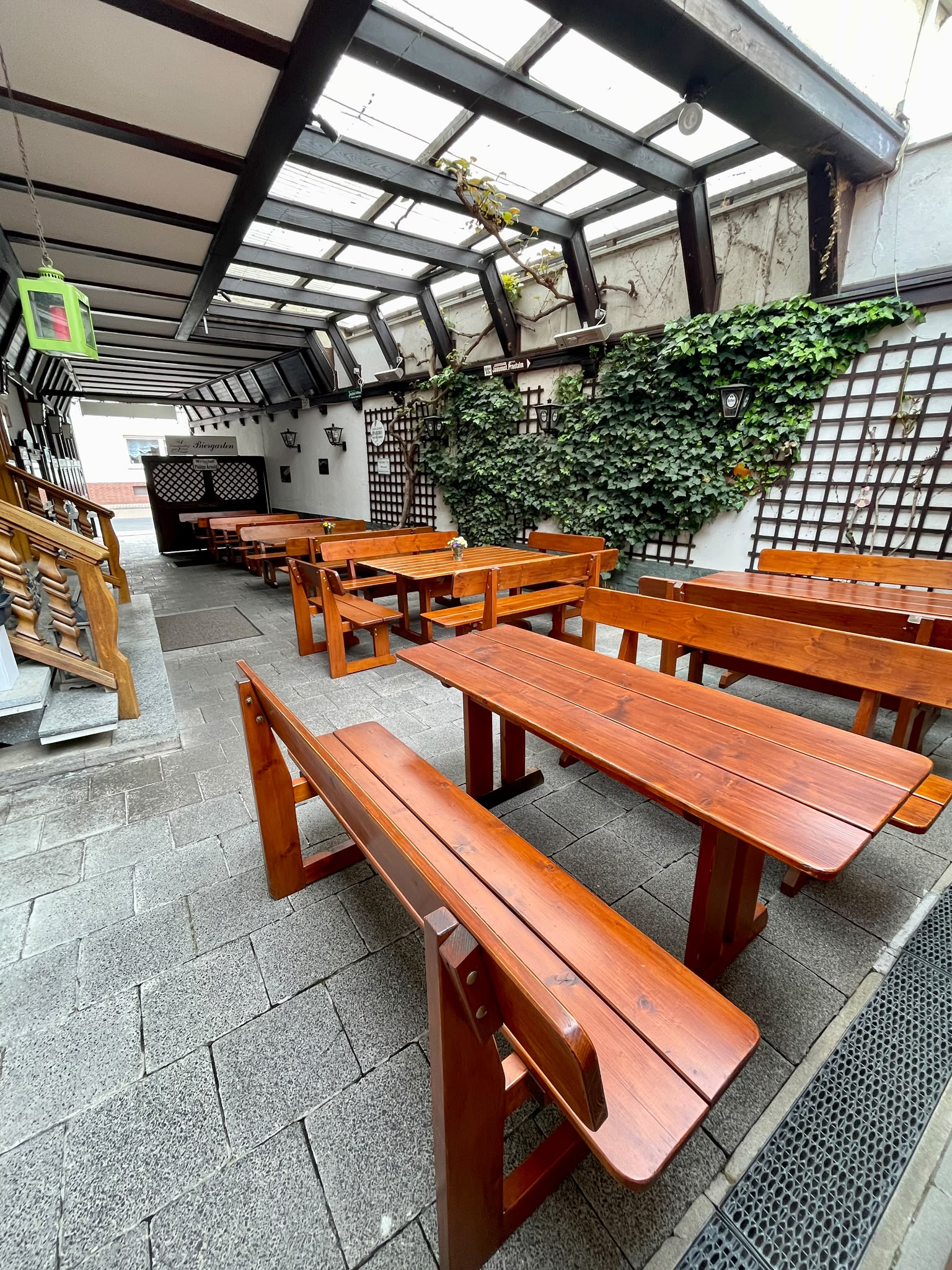 Gemütliche Biertischgarnituren unter dem Glasdach des Hofgartens