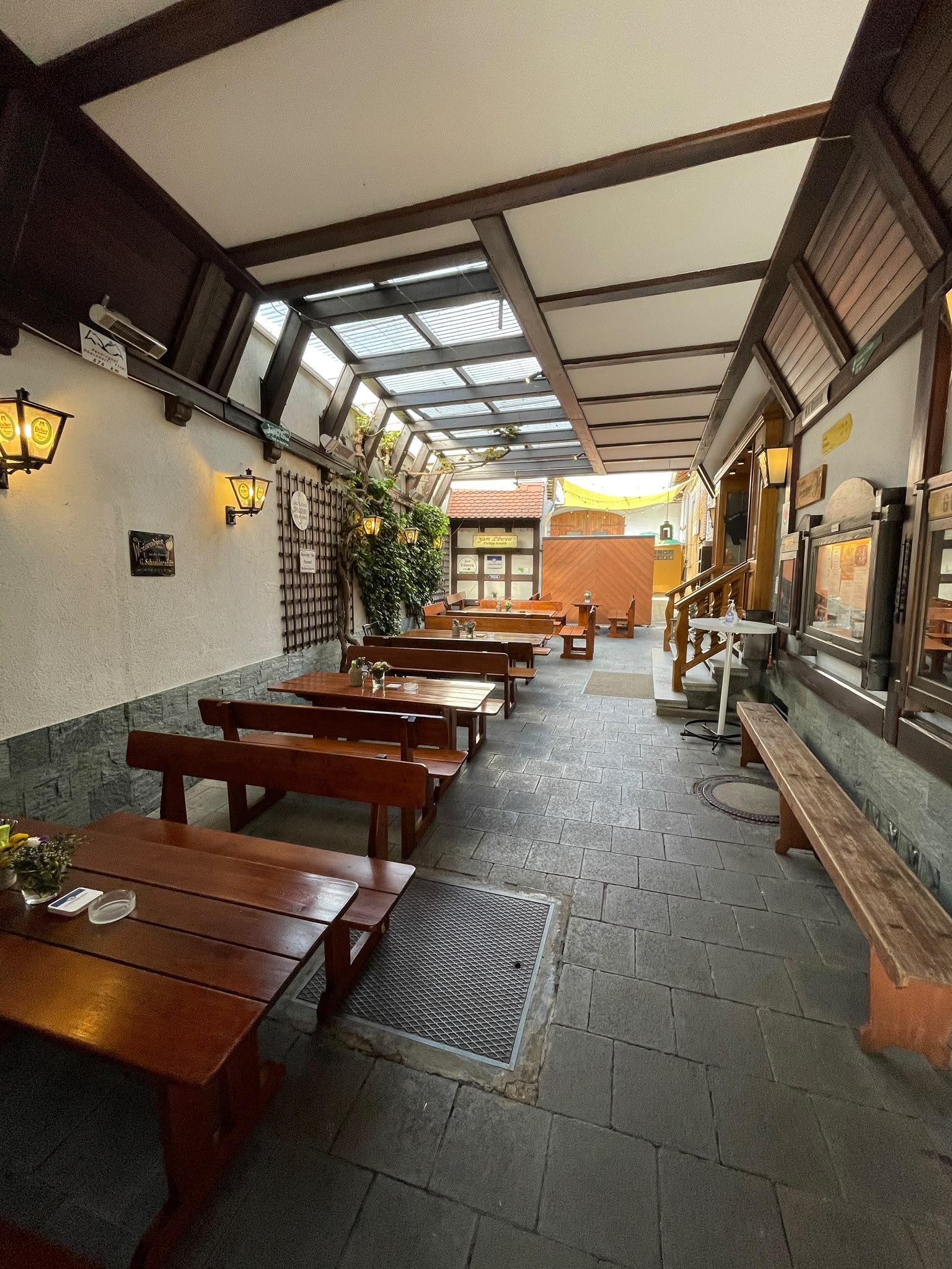 Biergarten mit traditionellen Garnituren und Blick zum Gasthaus „Zum Löwen“