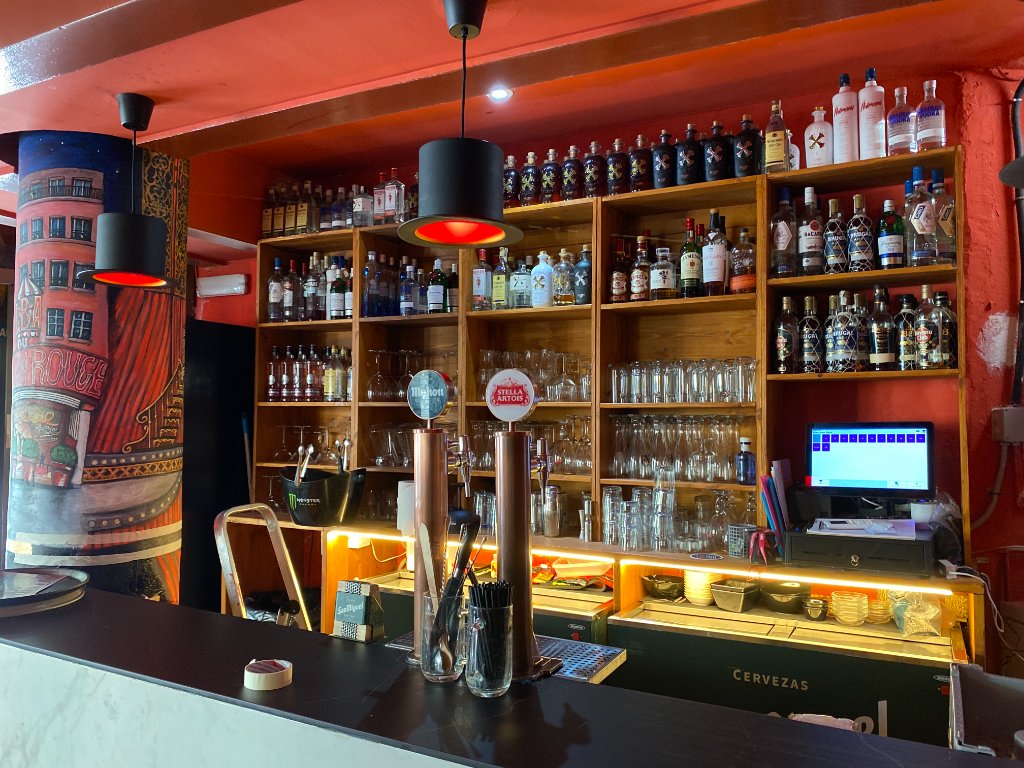 Barra del Café Tocado con estantería de licores y lámparas de chistera