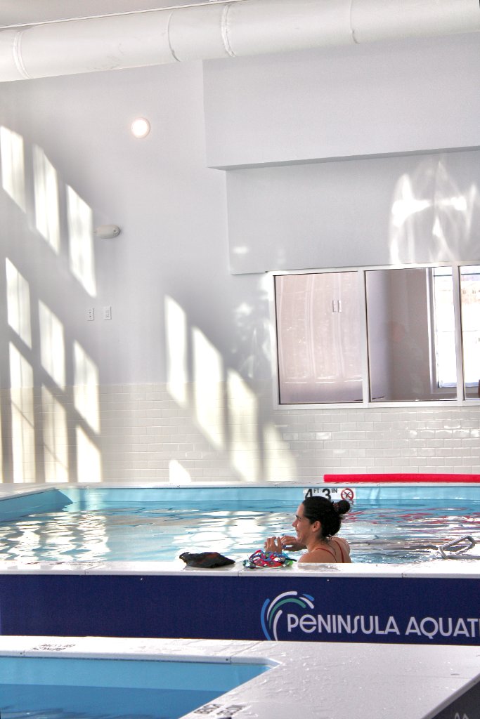 Kids lined up at pool watching instructor