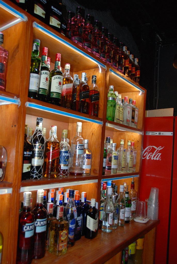 Botellas iluminadas en la estantería trasera