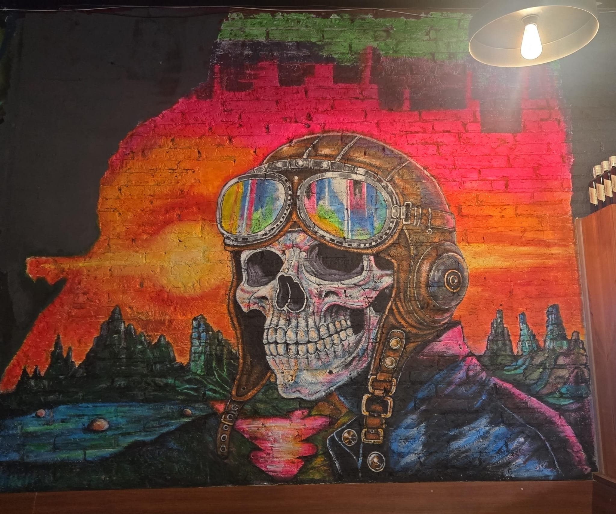 Mural de calavera con casco de aviador sobre ladrillo