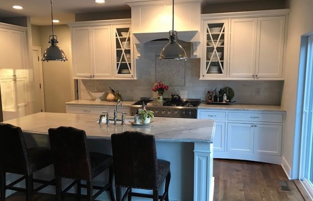 Transitional white kitchen with marble island and shaker cabinetry