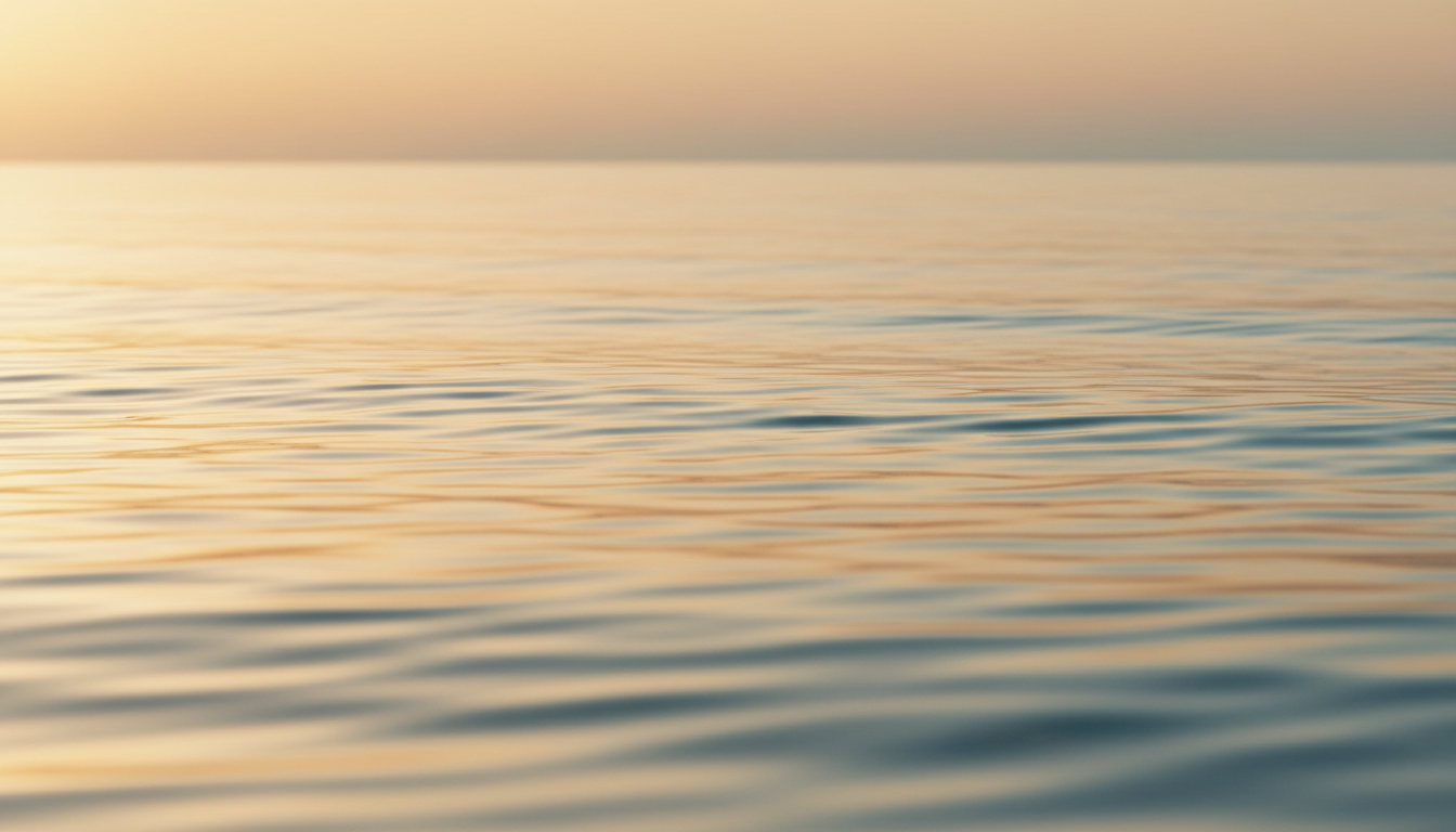 Serene ocean horizon at dawn with silky water and warm golden light