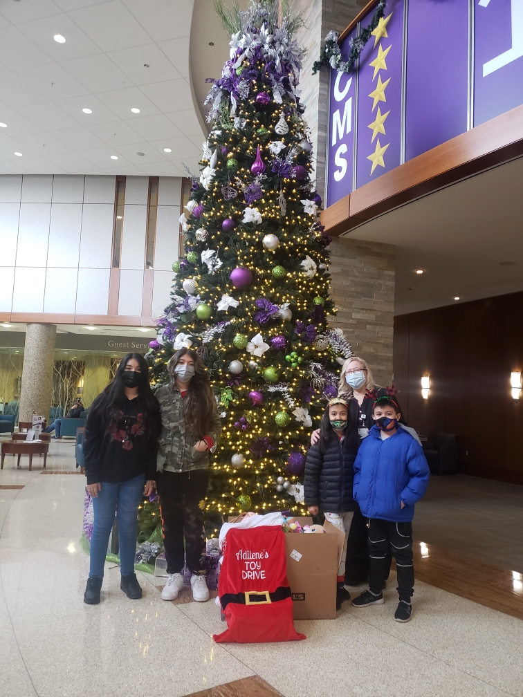 Adilene's Toy Drive at Christmas — community children around a Christmas tree