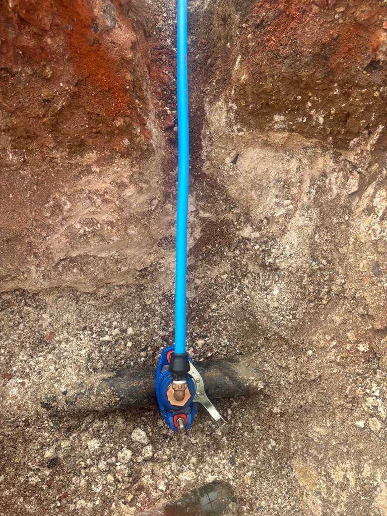 Water main installation showing new water pipe connection with tapping tee service saddle on existing water main by Subsoil Land & Water, water utility contractors in Battle, East Sussex and the South East