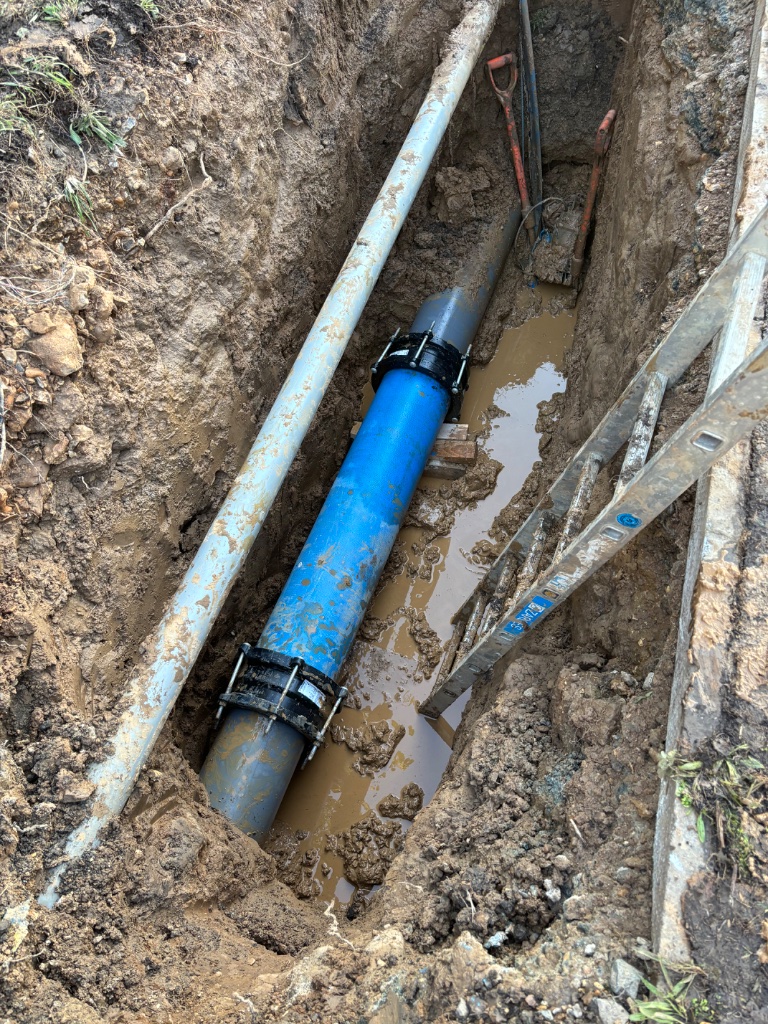 Water main cut out and repair using flanged Maxi couplings to remove damaged blue MDPE pipe by Subsoil Land & Water on private estate in Battle East Sussex