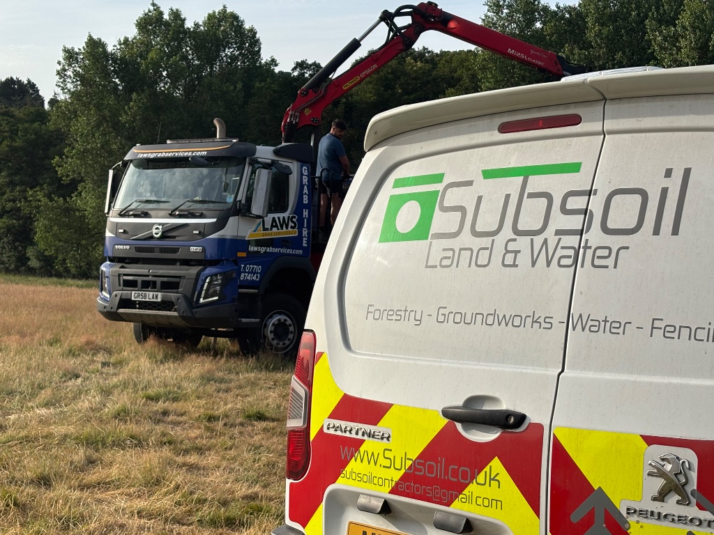 Subsoil Land & Water branded van and grab hire truck on-site during large pond construction, ditching and specialist water management project in Battle, East Sussex — water management, dredging and wildlife area creation contractors serving Kent and East Sussex