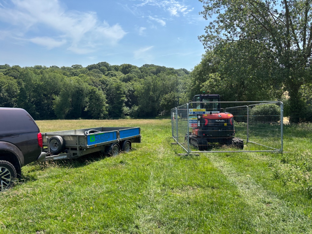 Kubota mini excavator on Subsoil Land & Water trailer during large pond construction, ditching and specialist water management project in Battle, East Sussex — pond construction and wildlife area creation contractors