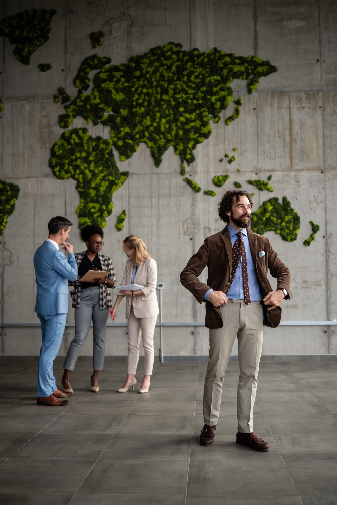 Corporate professionals collaborating before a world map of preserved moss