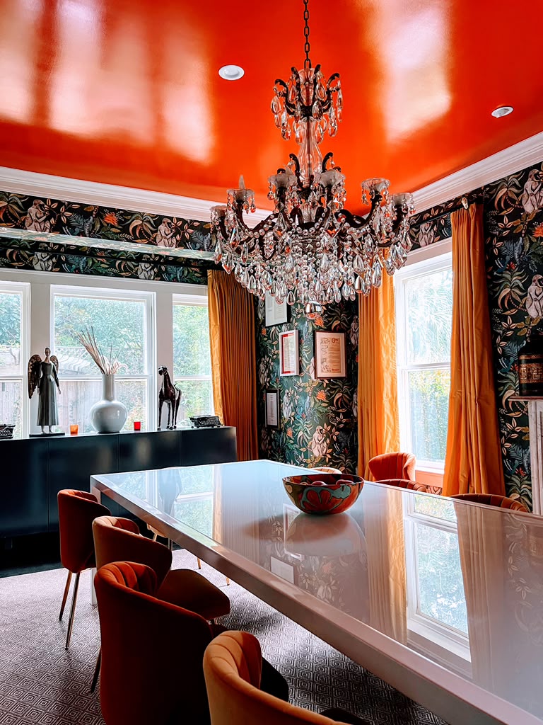 Houston dining room with decorative wallpaper, chandelier and orange chairs
