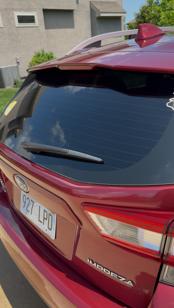 Red Subaru Impreza rear window and spoiler gleaming after exterior detail