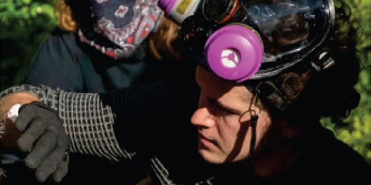 Hoopes at protest — gas mask with pink filters