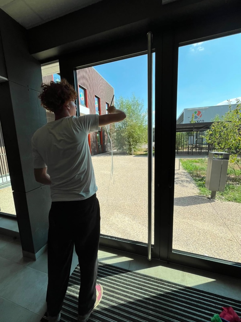 Sandro nettoyant une porte vitrée
