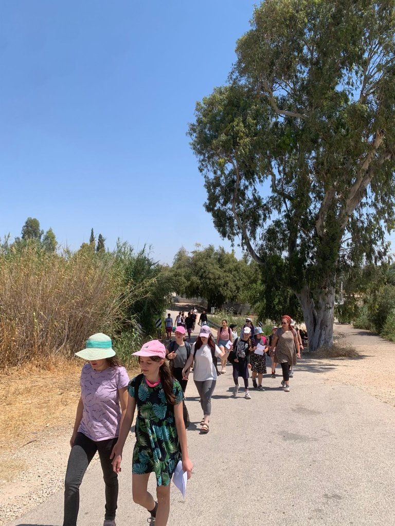 קבוצת נערים ובני משפחה בטיול בדרך כפרית