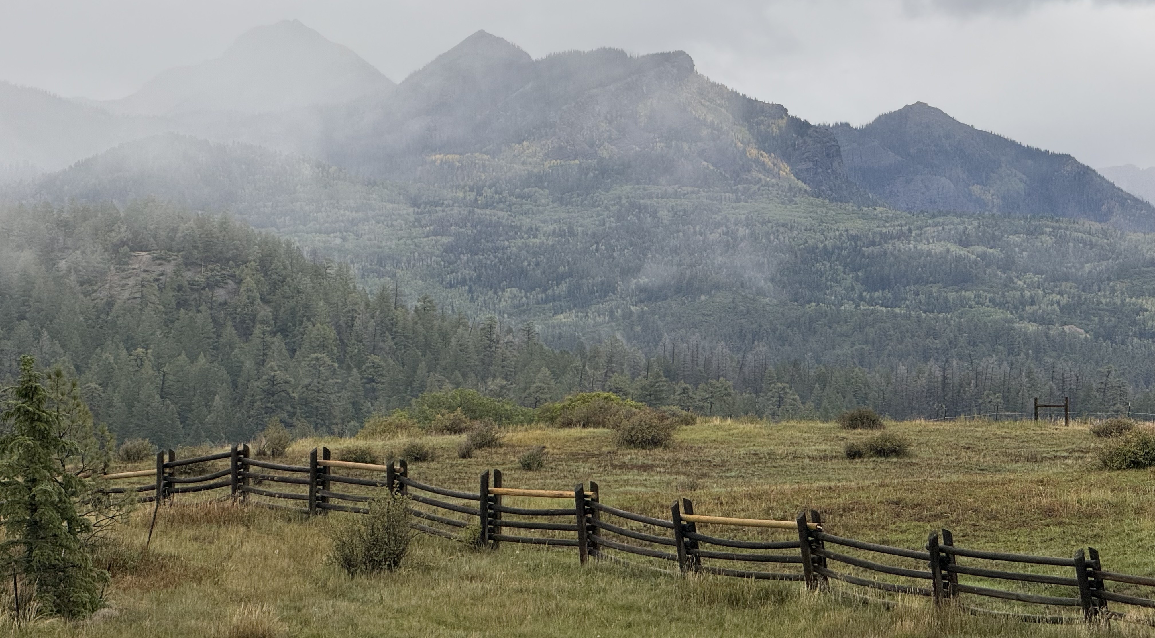 Misty mountain landscape with rustic wooden fence