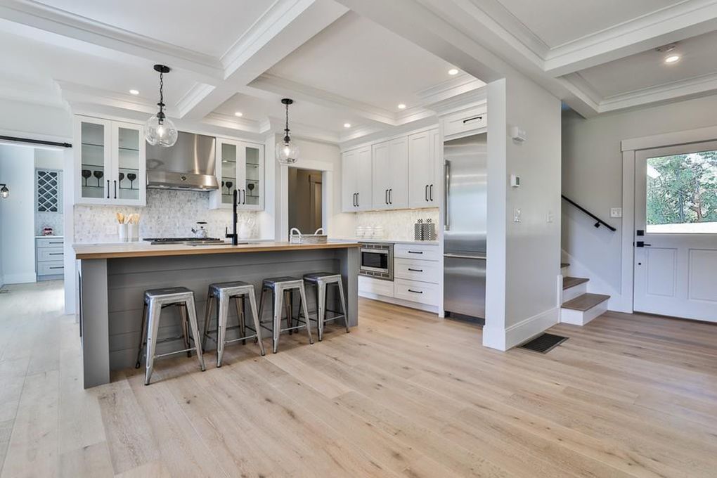 54 Hay St — kitchen with grey-blue island, wood countertop, and adjacent staircase