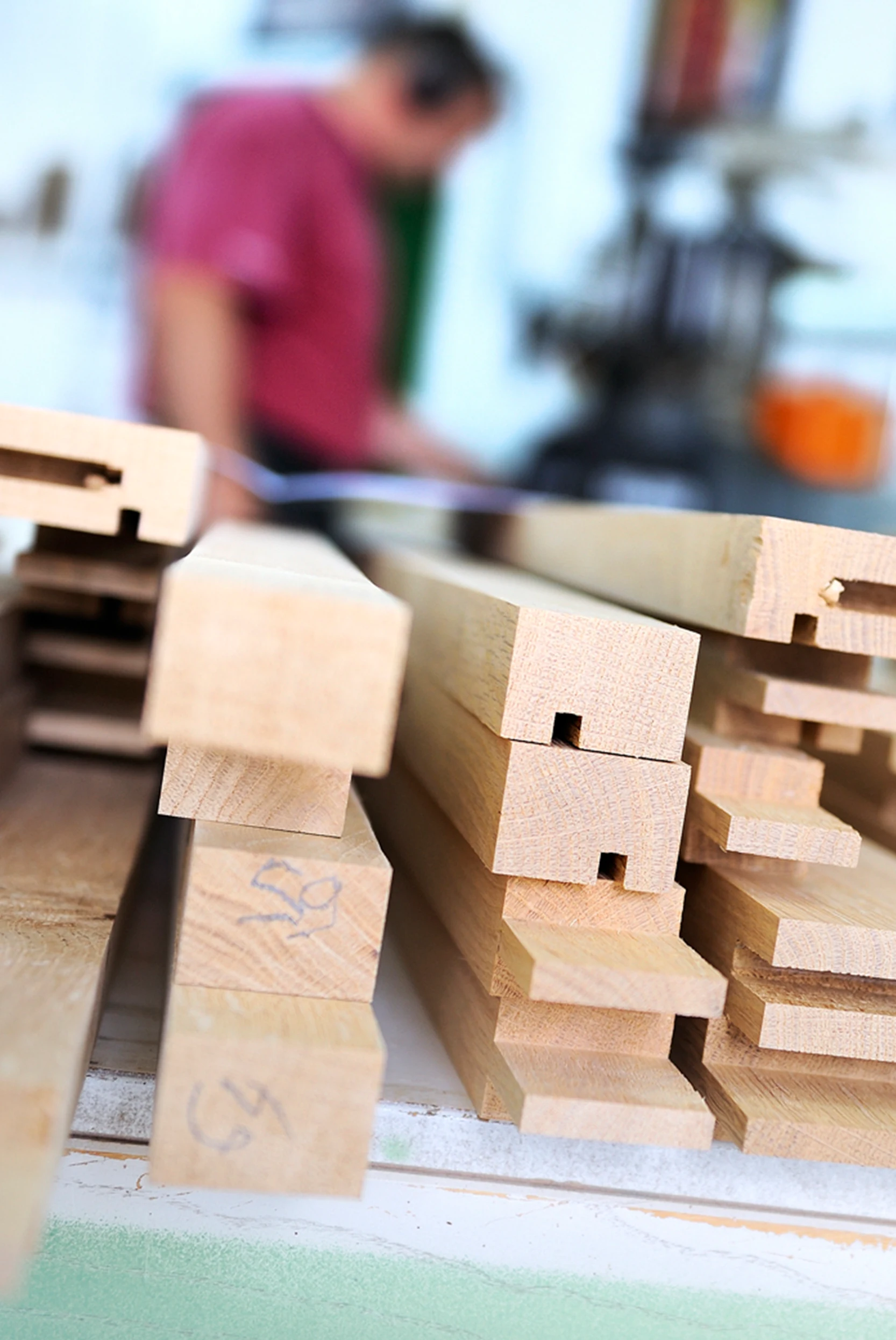 Stacked oak beams with joinery cuts in the Bruno Boulay workshop