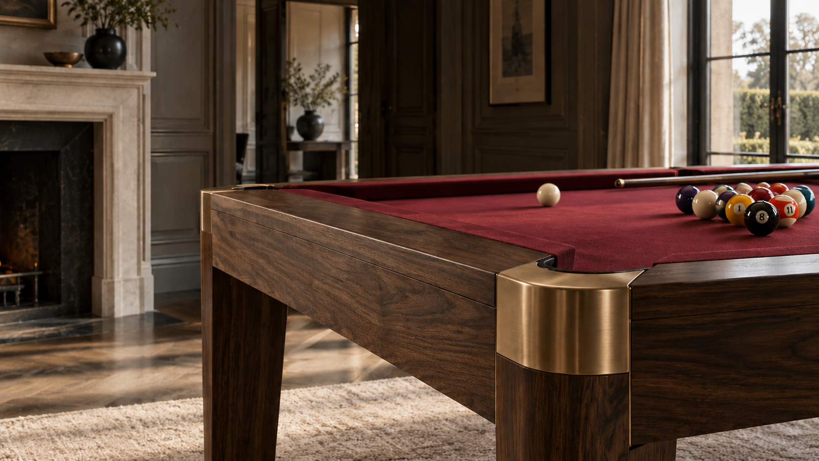Bespoke walnut billiards table with brushed brass details and burgundy cloth in a formal interior