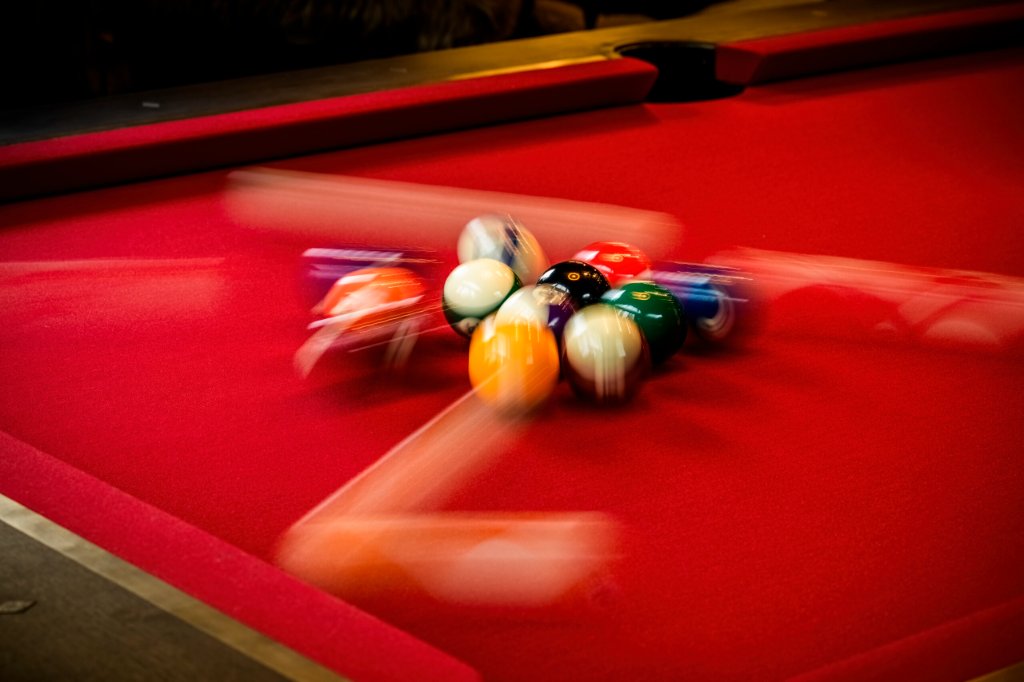 Professional slate bed beneath a handcrafted hardwood pool table