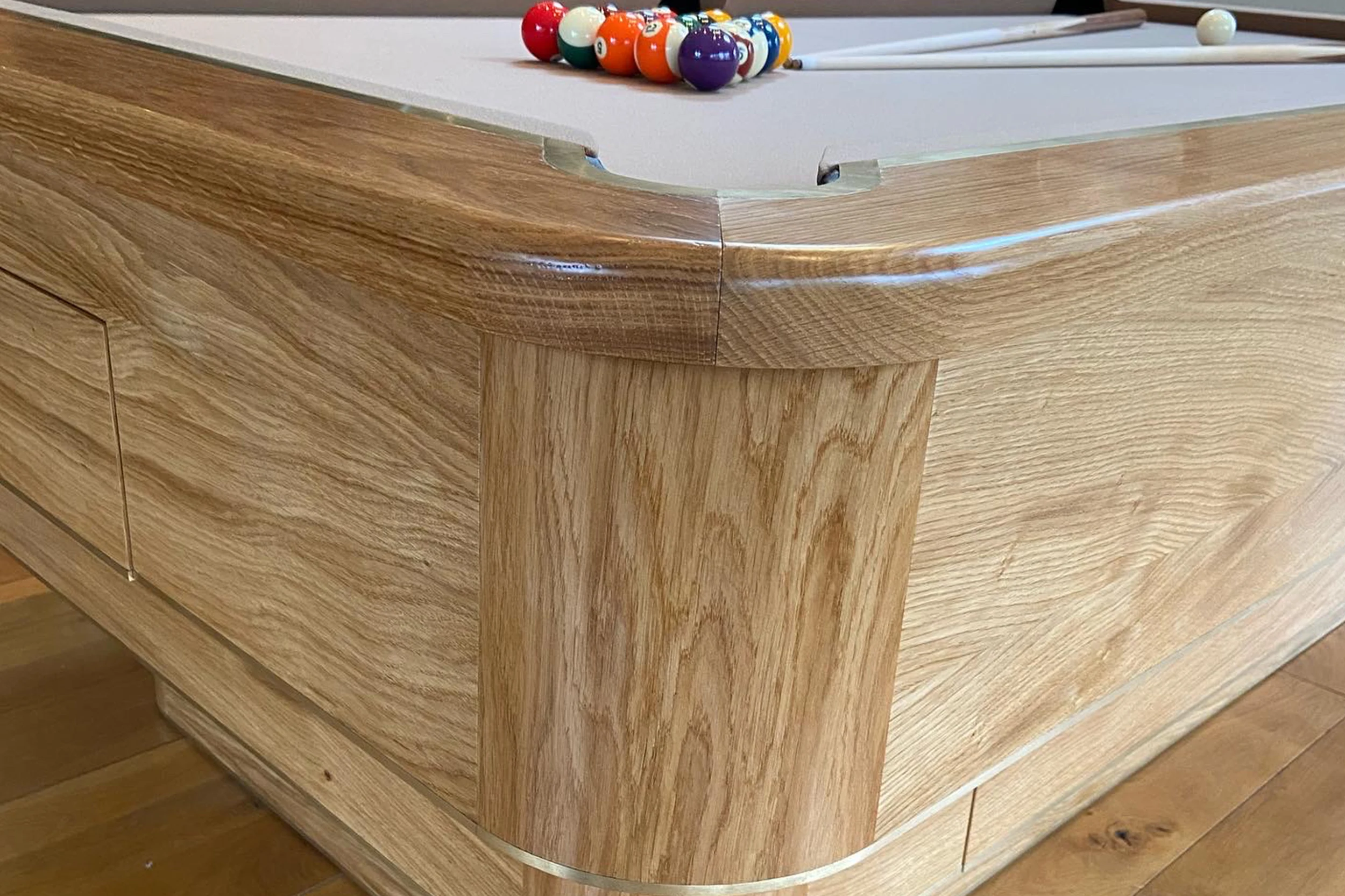 Close-up of a hand-finished European Oak rail corner on a bespoke pool table
