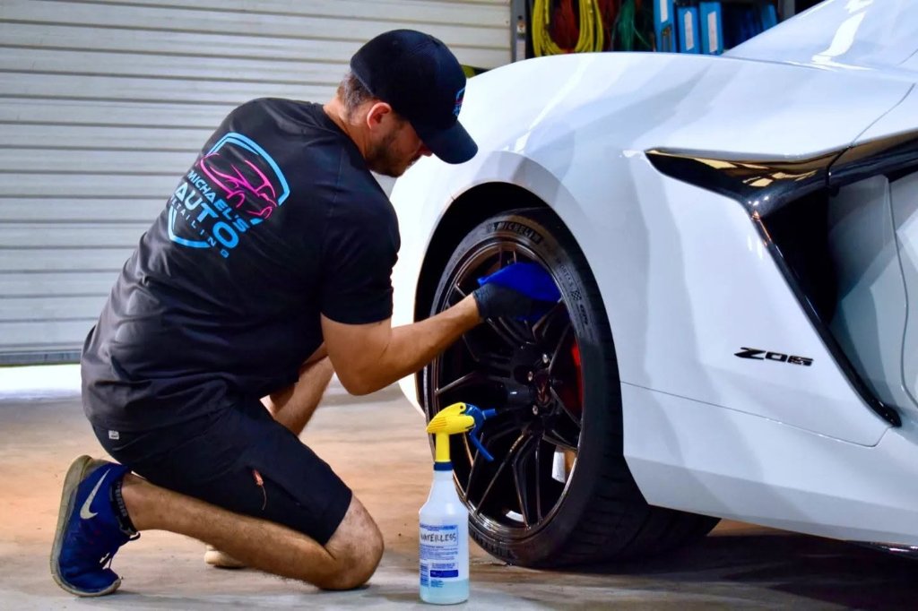 Detailer cleaning a Corvette wheel at Michael's Auto Detailing