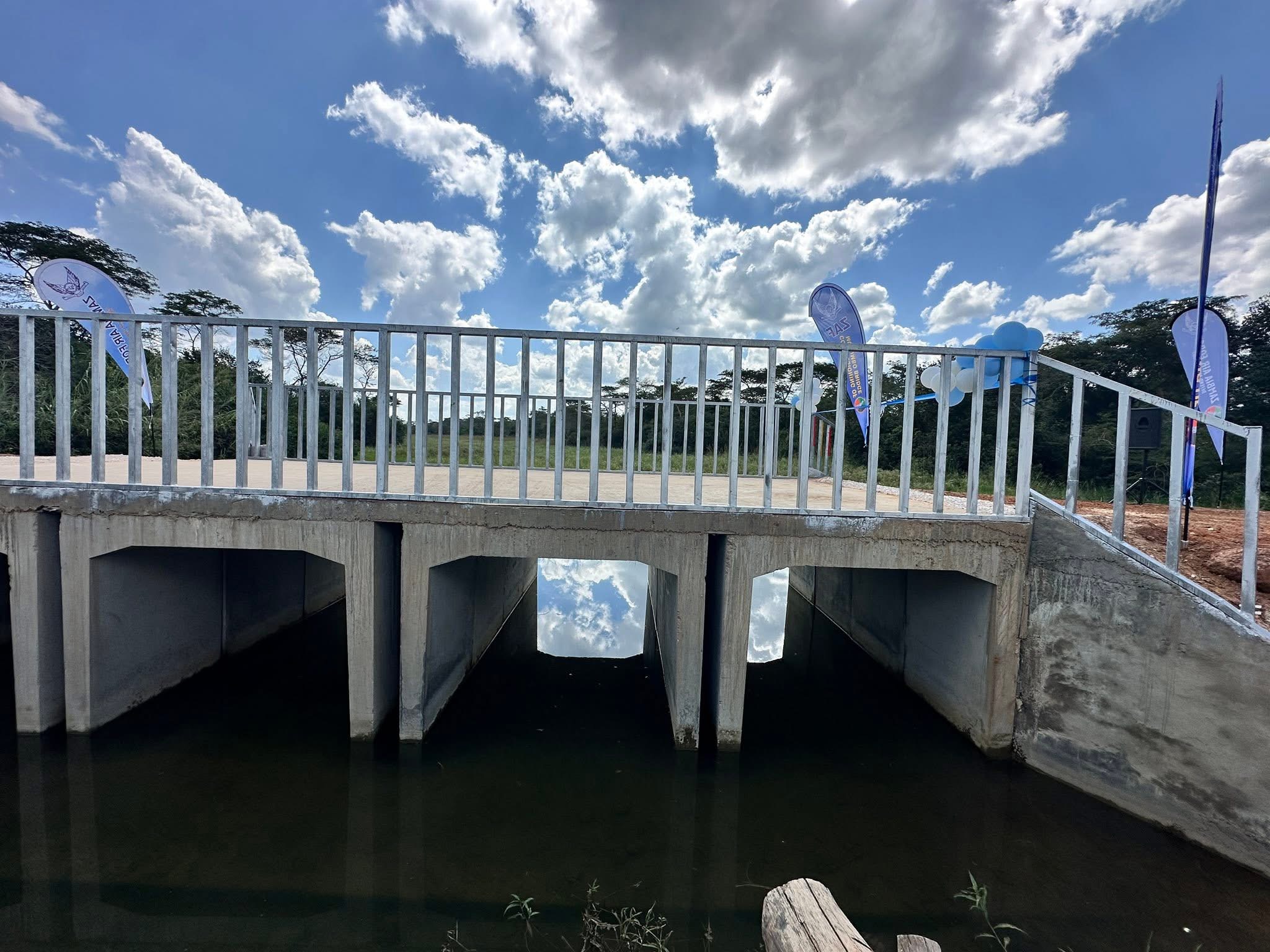 A completed precast concrete culvert bridge with railings and banners